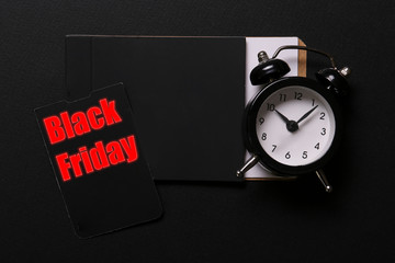 Wall Mural - Black friday sale concept. Fourth Friday of November, beginning of Christmas shopping season since 1952. Old alarm clock, text on paper textured background. Copy space, close up, top view, flat lay