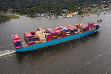 Aerial view of cargo ship entering port. 