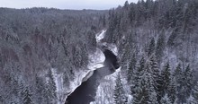 Small Meandering River In Snow Covered Forest In Winter - Aerial Drone Shot
