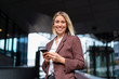 © Daniel Ingold/Westend61 - Portrait of happy young businesswoman with mobile phone in the city