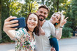 © WILLIAM PERUGINI/Westend61 - Group of three friends taking selfie with smartphone