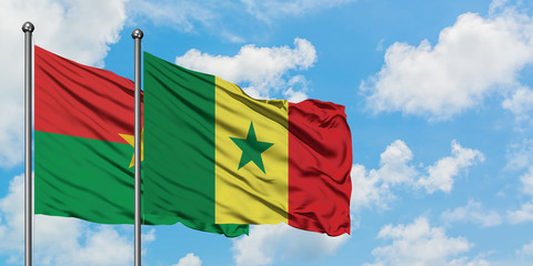 Burkina Faso and Senegal flag waving in the wind against white cloudy blue sky together. Diplomacy concept, international relations.