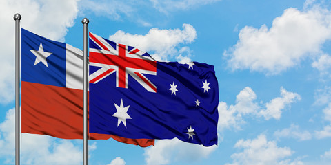Chile and Australia flag waving in the wind against white cloudy blue sky together. Diplomacy concept, international relations.