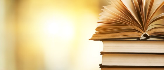Wall Mural - open book on yellow blurred background