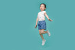 © DN6 - Excited Asian little girl jumping in mid-air, empty space in studio shot isolated on colorful blue background