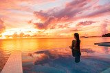 Fototapeta Zachód słońca - Paradise sunset idyllic vacation woman silhouette swimming in infinity pool looking at sky reflections over ocean dream. Perfect amazing travel destination in Bora Bora, Tahiti, French Polynesia.