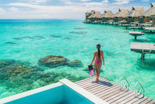 Luxury Overwater Bungalows Tahiti Resort Woman Going Snorkeling From Private Hotel Room On Bora Bora Island, French Polynesia. Travel Vacation Recreational Activity Watersport Fun Leisure.