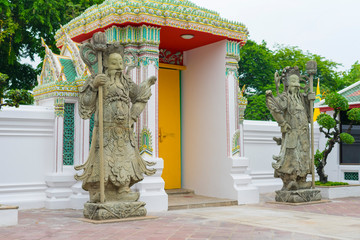 Wall Mural - Stone carving of giants in front of the gate of Wat Pho in Bangkok, Thailand.  B