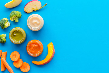 Wall Mural - Vegetable and fruits puree for feed babies on blue background top view space for text