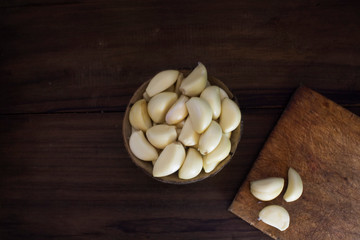 Organic fresh garlic in coconut shell with an elegant black wood background