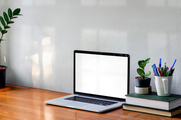 Wall Mural - Workspace with laptop computer, book and houseplant on wooden table white concrete wall.