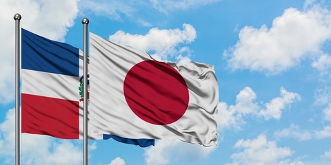 Dominican Republic and Japan flag waving in the wind against white cloudy blue sky together. Diplomacy concept, international relations.