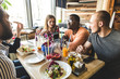 © xartproduction - A company of multicultural  young people in a cafe eating pizza, drinking cocktails, having fun