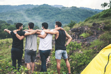 Cheerful Young  Man Traveler Friends Hugging With Hands Raise Up Together At Nature,Enjoying Backpacking Concept,Back View