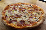 Fototapeta Uliczki - Calabrian pizza with ham, mushroom and cheese on a white plate.
