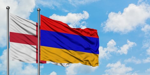 England and Armenia flag waving in the wind against white cloudy blue sky together. Diplomacy concept, international relations.