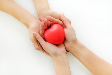 2 people stack their hands together with red rubber heart, with feeling of delivering or receiving of love, care, safe, thanks. Can be have as Valentine's Day, Birthdays or other day that is needed.