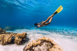 © artifirsov - Woman freediver glides over sandy sea with yellow fins in transparent sea. Freediving in Mauritius