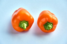 Small Bell Peppers. Two Orange Mini Peppers On A Light Blue Background With Copy Space.