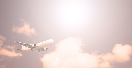 Passenger plane on the background of the sky with white clouds, the sun is shining.