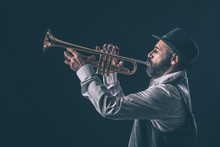 Profile View Of A Jazz Trumpet Player With Beard And Hat.