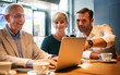 © leszekglasner - Business people looking at laptop at cafe and discussing