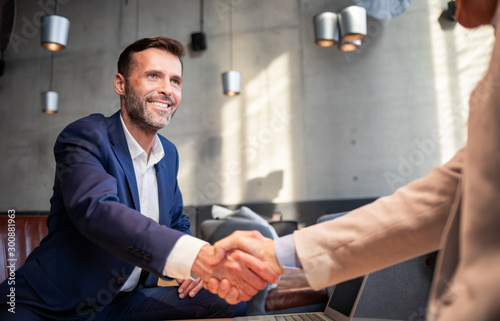 Fotomural Business people shaking hands during meeting in cafe