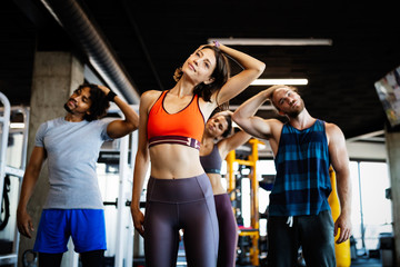 Beautiful fit people working out in gym together