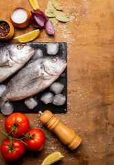 fresh fish on a cutting board with vegetables