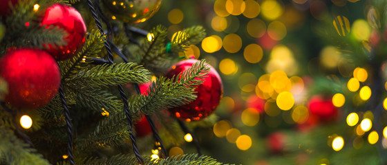 winter christmas holiday background - toys on a christmas tree branch and blurry lights in the backg