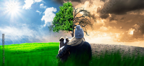 Fotomural Woman with dog is sitting in the lawn and watching the climate change