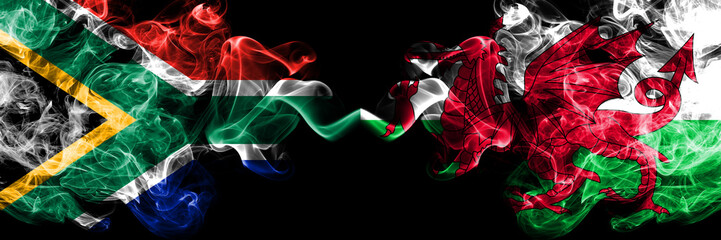 Wall Mural - South Africa vs Wales, Welsh smoky mystic flags placed side by side. Thick colored silky abstract smoke flags concept