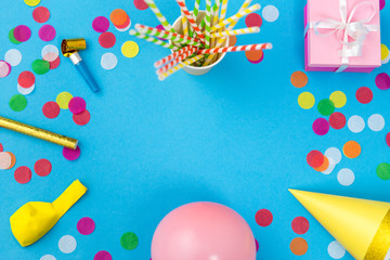 Wall Mural - celebration and decoration concept - pink birthday gift, party props, balloons and colorful confetti on blue background