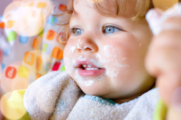 Poster - pretty baby in his high chair after eating a yogurt