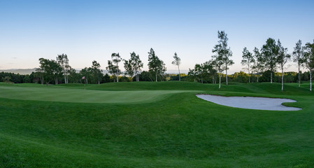 Wall Mural - Panorama View of Golf Course with beautiful putting green. Golf course with a rich green turf beautiful scenery.