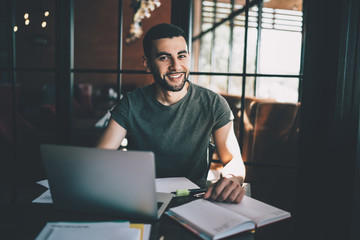 Smiling man with laptop sitting at table