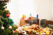 © Nattakorn - Christmas tree with decoration over table of food and turkey for thanksgiving dinner, blur background