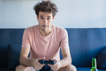 Young man playing video games at home.