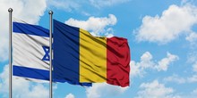 Israel And Romania Flag Waving In The Wind Against White Cloudy Blue Sky Together. Diplomacy Concept, International Relations.