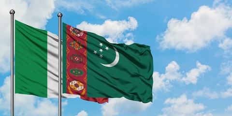Italy and Turkmenistan flag waving in the wind against white cloudy blue sky together. Diplomacy concept, international relations.