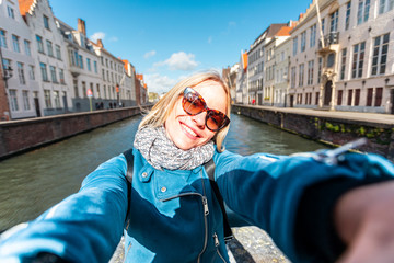 Wall Mural - Woman tourist sitting and enjoying a center of Bruges, Belgium