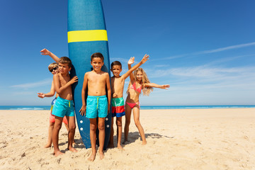 Wall Mural - Boy with friends stand by surfboard on the beach