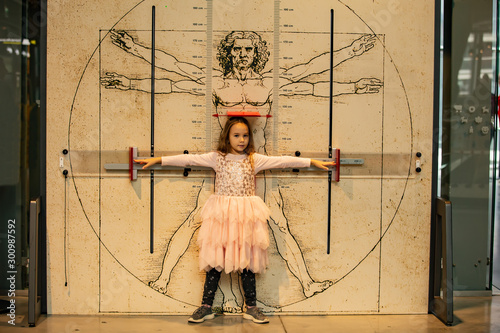Fotografía Little girl on the background of the Vitruvian man