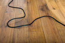 Black Electric Cable On Wooden Parquet Floor