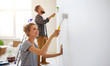 © JenkoAtaman - young happy couple is repairing and painting   wall at home