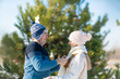 © Kate - guy wraps a girl in a warm white scarf while walking through a snowy winter forest