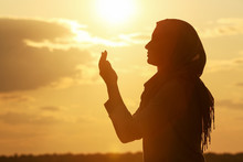 Beautiful Muslim Woman Praying Outdoors At Sunset