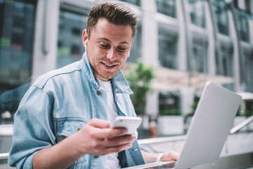 Millennial man using smartphone on street