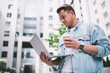 © BullRun - Cool young man having coffee and using laptop