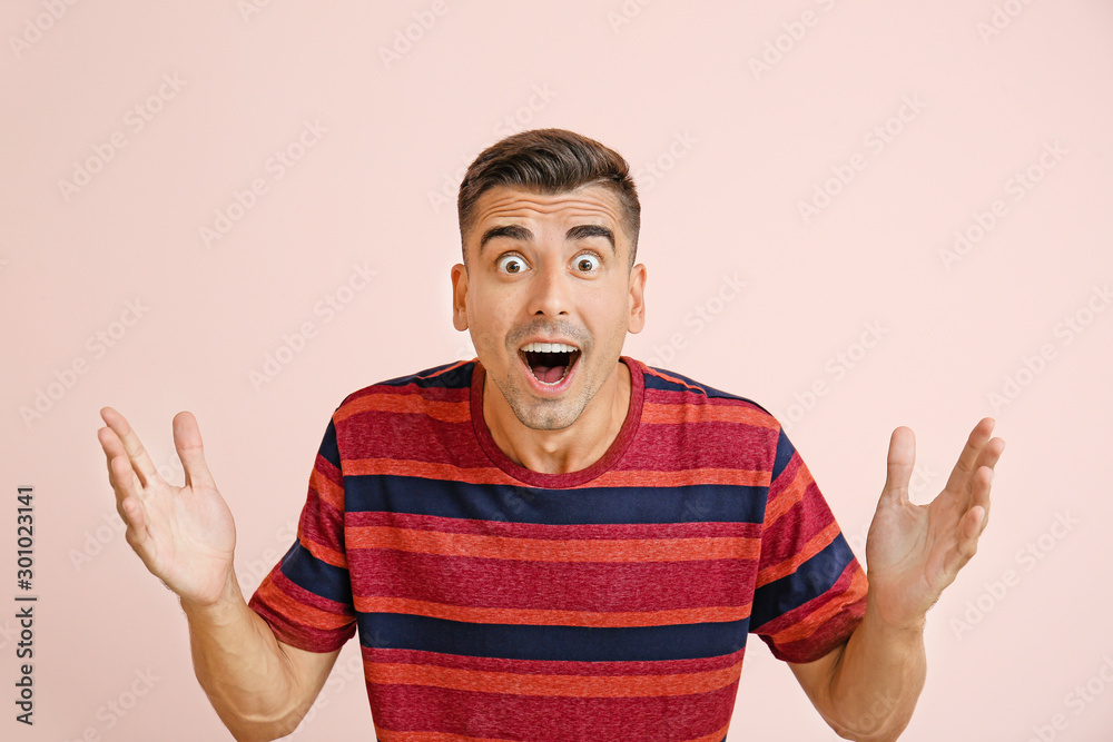 Surprised young man on color background